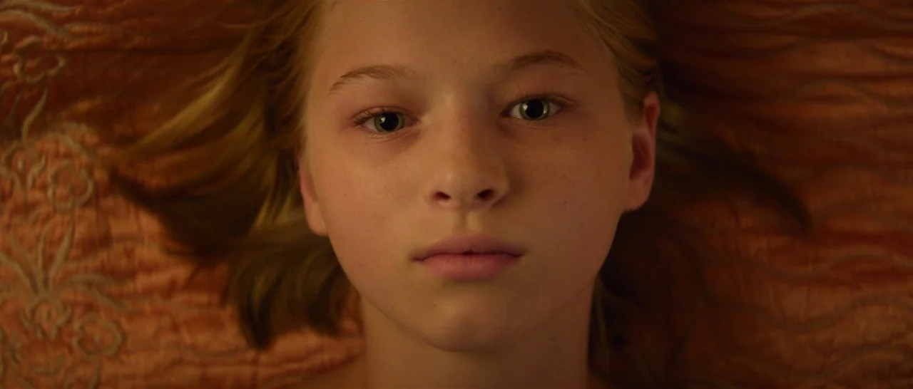 You Were Never Really Here (2017) movie still: closeup — A close-up shot of a young girl lying on a patterned, textured orange fabric. She is…