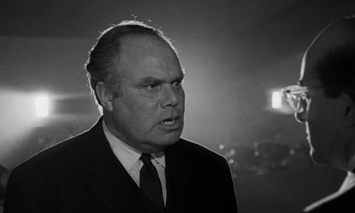 Dr. Strangelove or: How I Learned to Stop Worrying and Love the Bomb (1964) movie still: medium — A dimly lit office features two men in business…