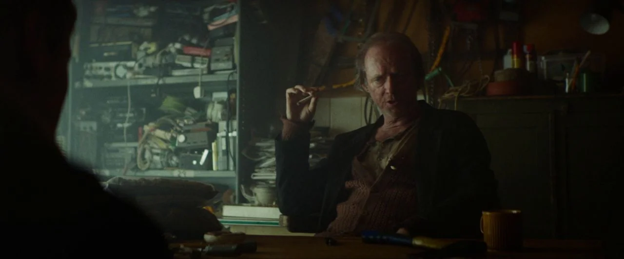 Calm With Horses (2019) movie still: medium — A cluttered room is filled with shelves of electronic equipment and miscellaneous household tools. A…