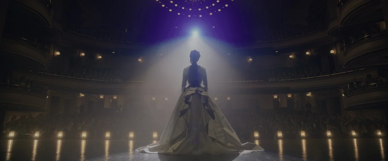 The Greatest Showman (2017) movie still: fullbody — A grand, multi-tiered opera house interior is filled with a seated audience in darkness. A woman…