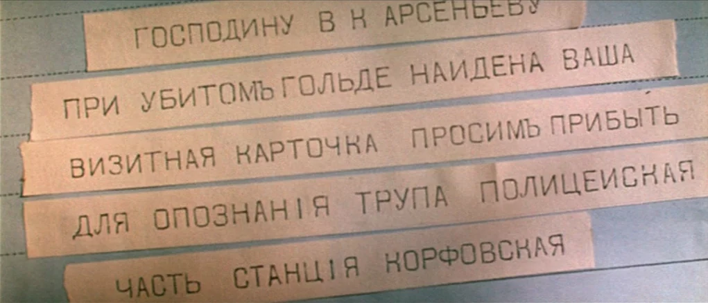 Dersu Uzala (1975) movie still: closeup — Several strips of cut paper with typed Russian text are pasted onto a document. The document features…