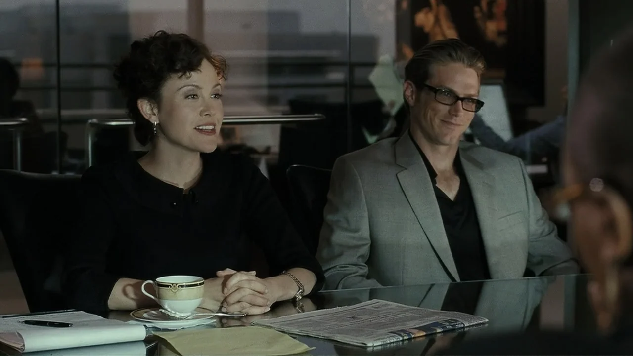 Mr. Brooks (2007) movie still: medium — A glass-walled modern office meeting space features a reflective table and blurred background windows. A man…