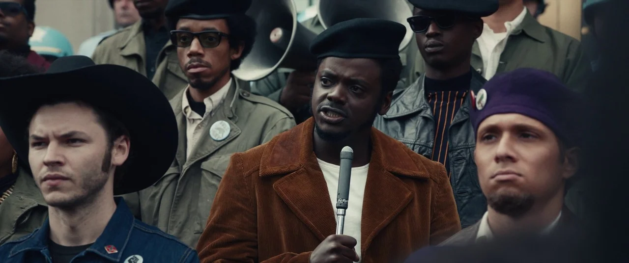 Judas and the Black Messiah (2021) movie still: medium — A group of diverse activists stands together in an outdoor area during the day. The central…