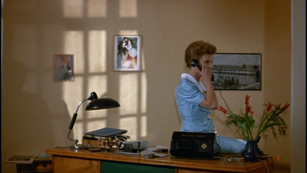 The Marriage of Maria Braun (1979) movie still: medium — A 1950s style office features beige walls with framed pictures and window shadow patterns.…
