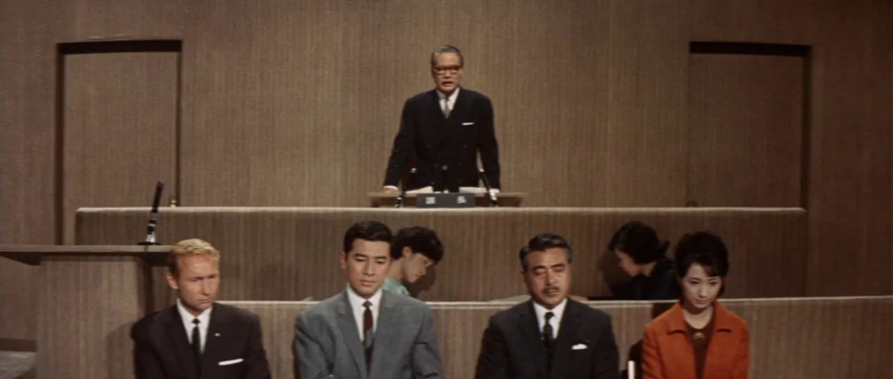 Invasion of Astro Monster (1965) movie still: wide — A wood-paneled room features a central lectern flanked by plain wall sections. Five people sit…