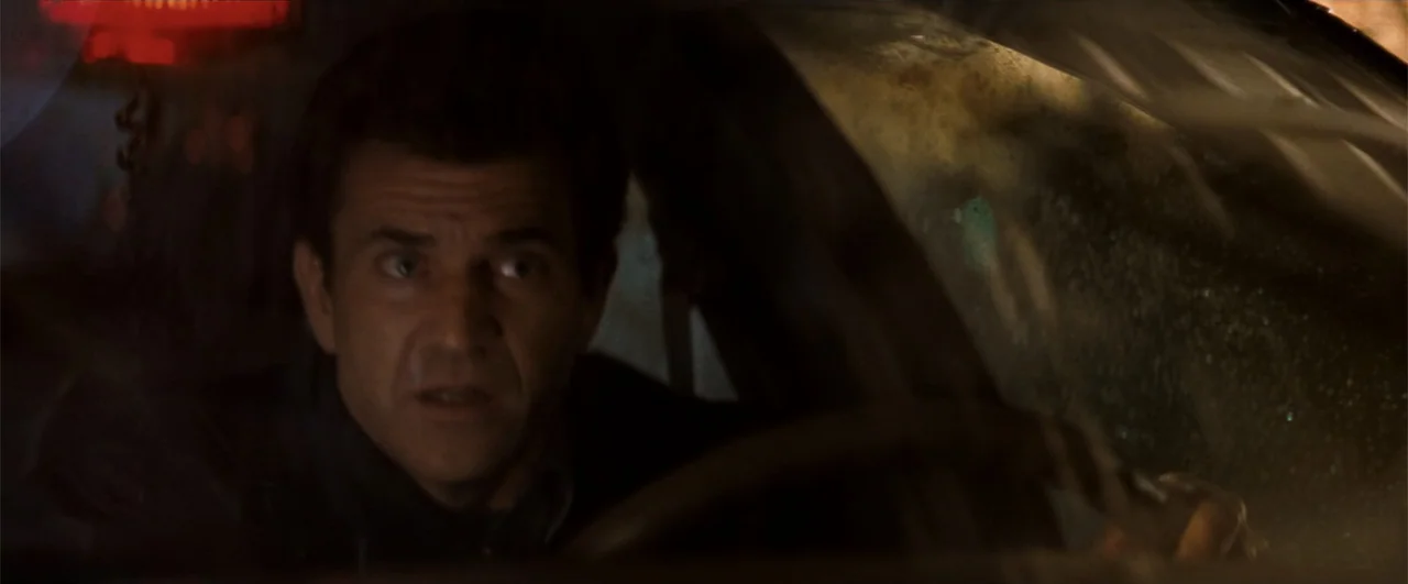 Lethal Weapon 4 (1998) movie still: medium — A dark car interior at night with a driver visible behind the steering wheel. The man looks ahead and…