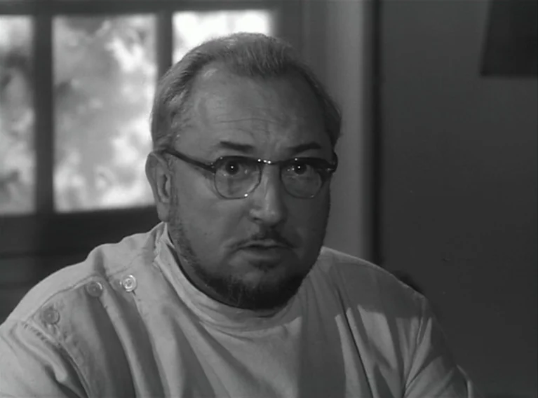 Head Against The Wall (1959) movie still: closeup — An interior space with a window partially visible in the background. A middle-aged man in…