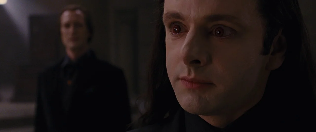 The Twilight Saga: Breaking Dawn – Part 2 (2012) movie still: closeup — A dark, dimly lit corridor serves as the setting for two pale men. The man…