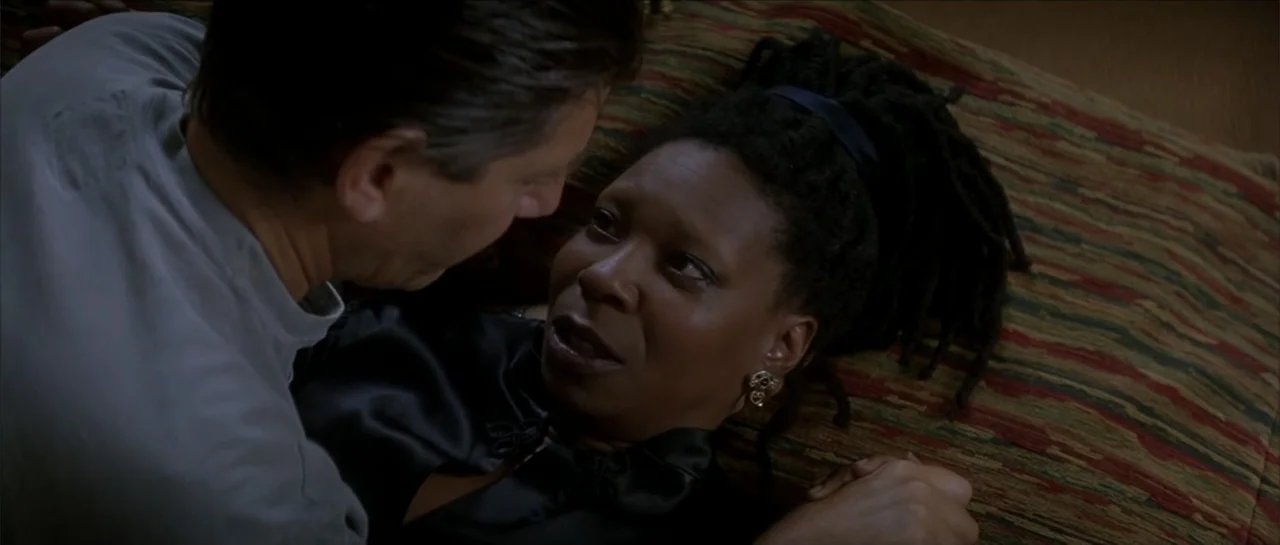 Moonlight and Valentino (1995) movie still: medium — A dimly lit room features a woman lying on a textured, patterned bed spread. A man leans over…