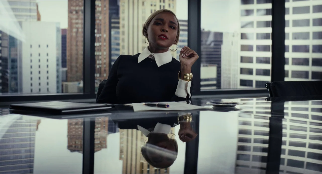 Glass Onion (2022) movie still: medium — A modern high-rise glass conference room overlooks a dense urban cityscape with large windows. A woman…
