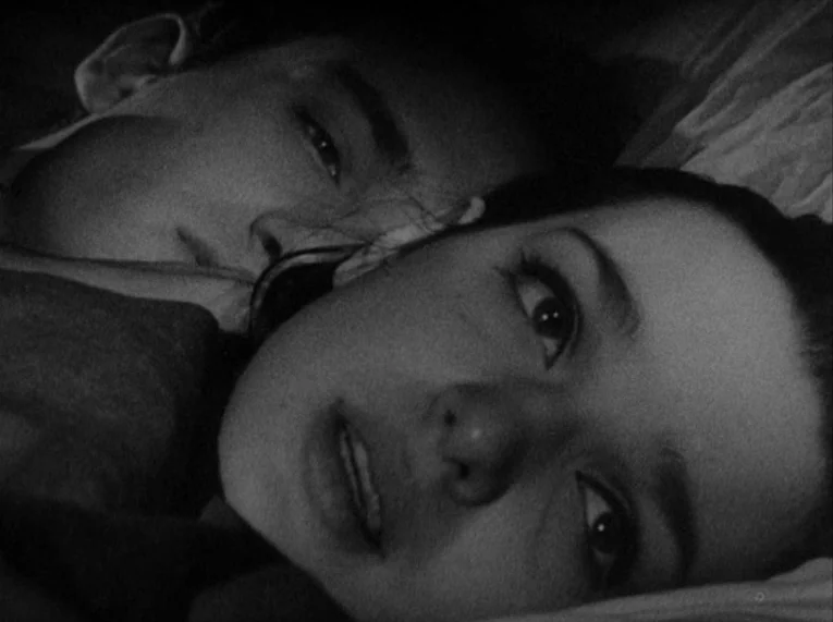 Shadows (1958) movie still: closeup — A man and a woman lie together on a white pillow in a dark room. Both subjects stare upward toward the camera.
