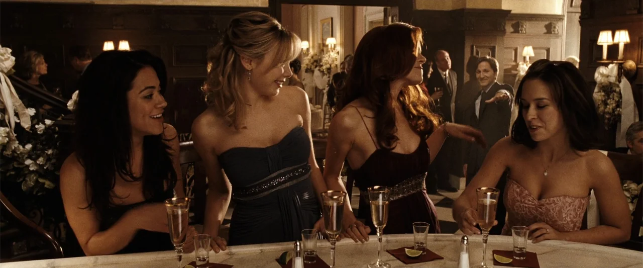 Ghosts of Girlfriends Past (2009) movie still: medium — A crowded reception hall features a marble bar with decorative floral arrangements and…