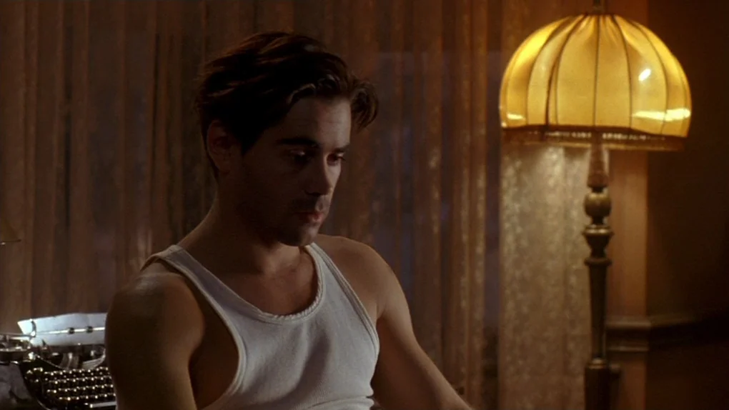 Ask The Dust (2006) movie still: medium — A dimly lit room features a vintage floor lamp and a typewriter on a table. A man in a white tank top sits…