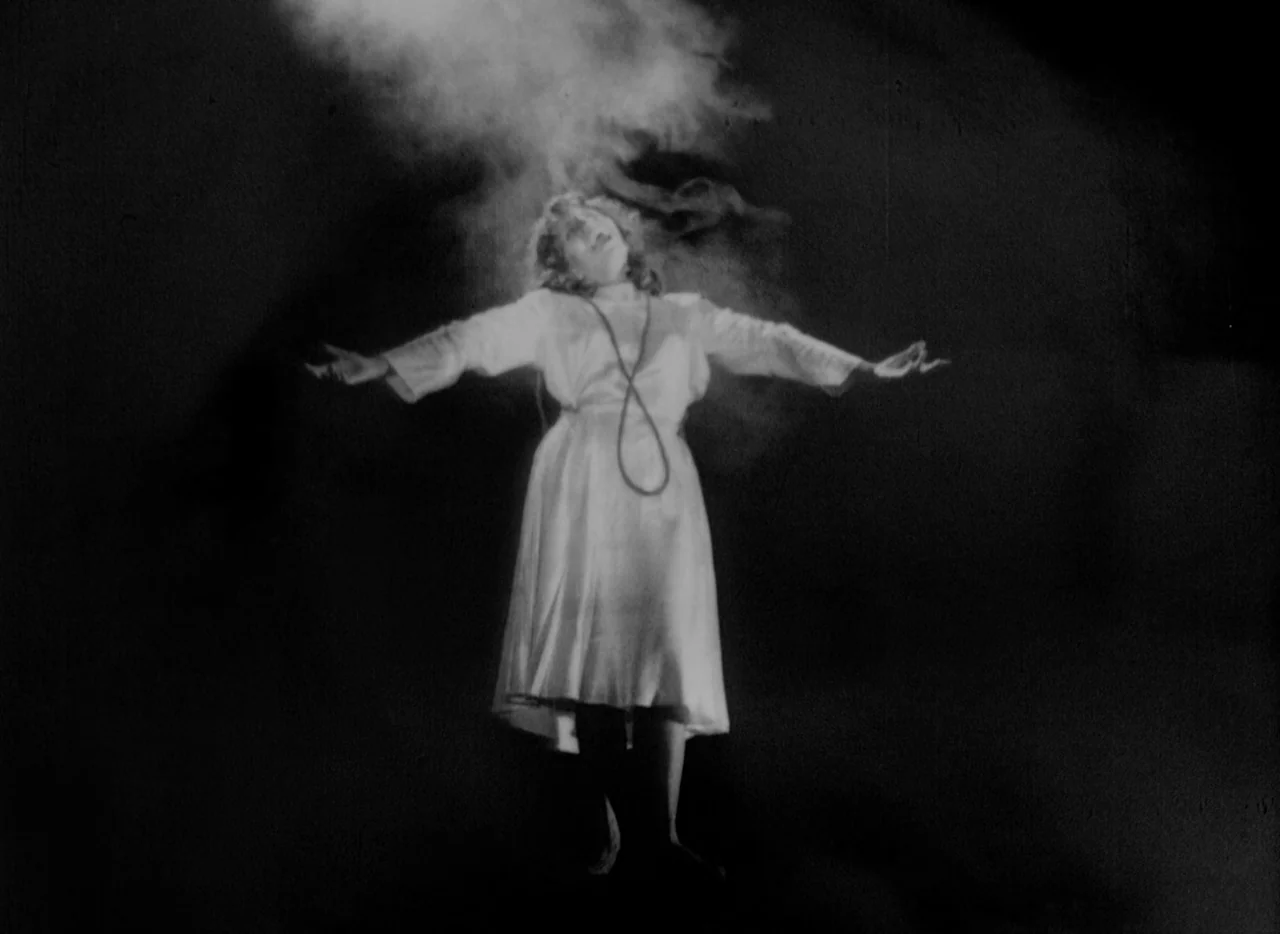 At Midnight I’ll Take Your Soul (1964) movie still: fullbody — A woman stands centered against an impenetrable black background with swirling smoke…