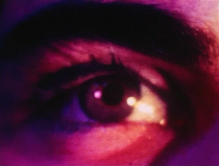 Pink Narcissus (1971) movie still: closeup — This is an extreme close-up shot of a single human eye. Light reflects intensely off the pupil while…