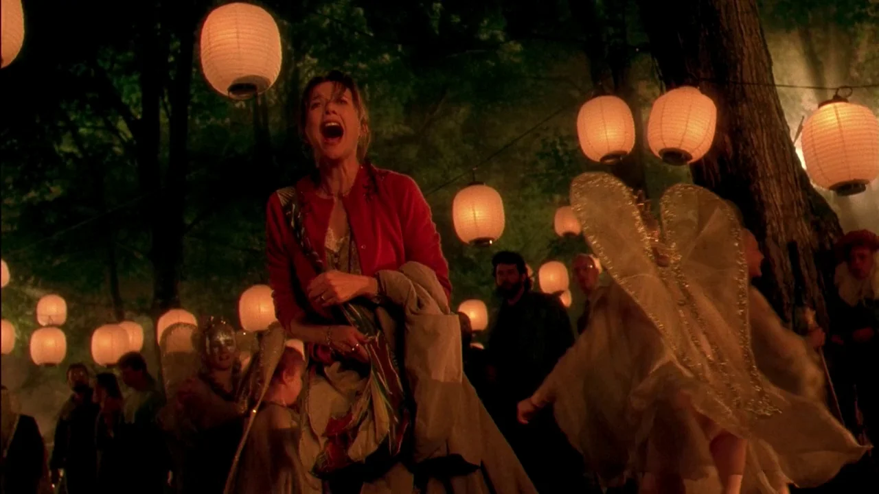 In Dreams (1999) movie still: medium — A nighttime outdoor event in a wooded area is lit by glowing paper lanterns. A woman stands in the center…