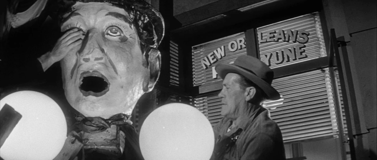 The Tarnished Angels (1957) movie still: medium — An exterior storefront displays a sign reading New Orleans with neon-style lettering. A large…
