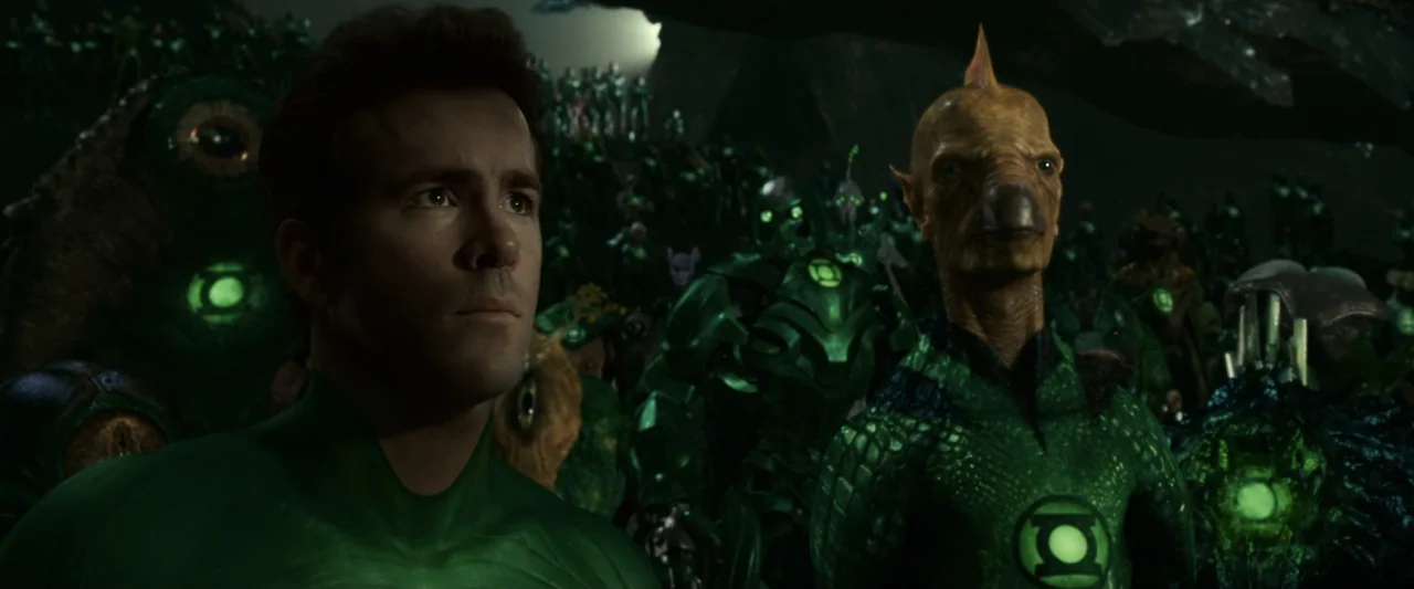 Green Lantern (2011) movie still: medium — A dark subterranean space filled with a large crowd of diverse extraterrestrial figures. A human man in a…