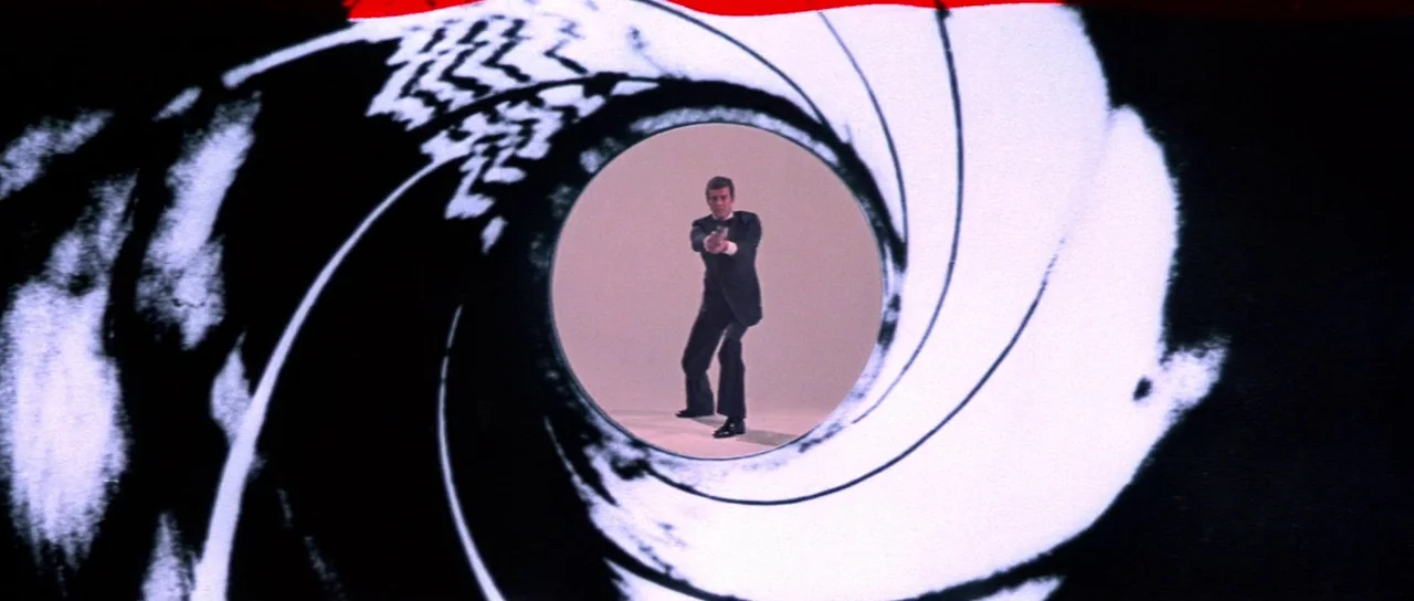 For Your Eyes Only (1981) movie still: wide — The frame shows a man centered within a stylized white circular aperture. A swirling black and white…