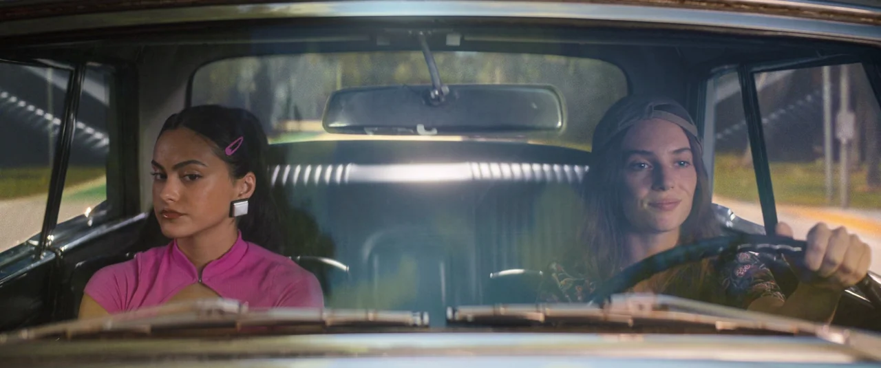Do Revenge (2022) movie still: medium — The interior of a car at night shows two women riding in the front seats. They appear to be traveling as the…