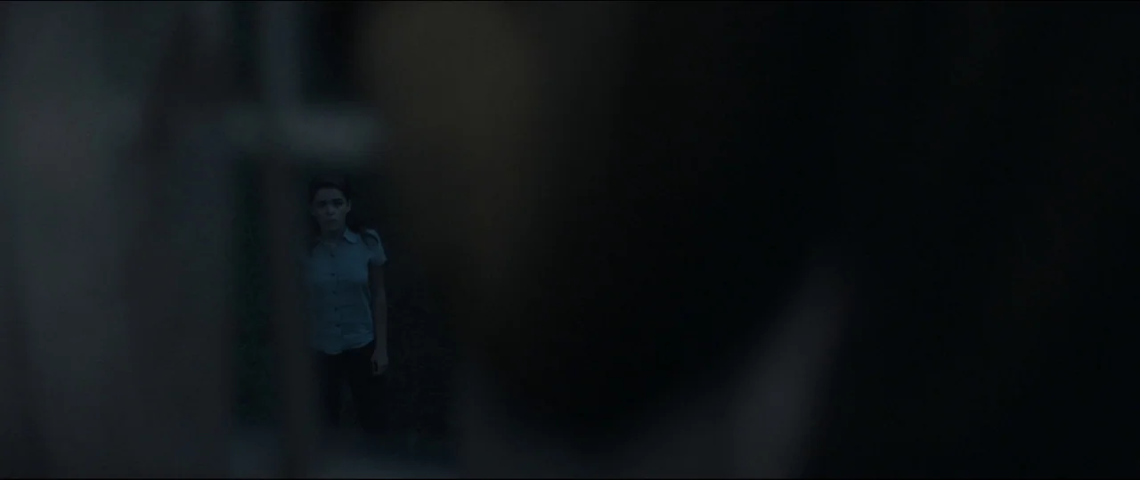 One & Two (2015) movie still: wide — A dark outdoor space with indistinct surroundings obscured by heavy shadows and low light. A young woman stands…
