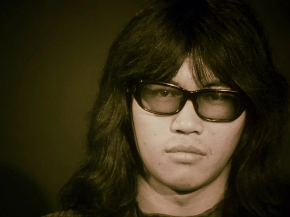 Throw Away Your Books, Rally in the Streets (1971) movie still: closeup — A person with long hair poses against a plain dark studio background. The…