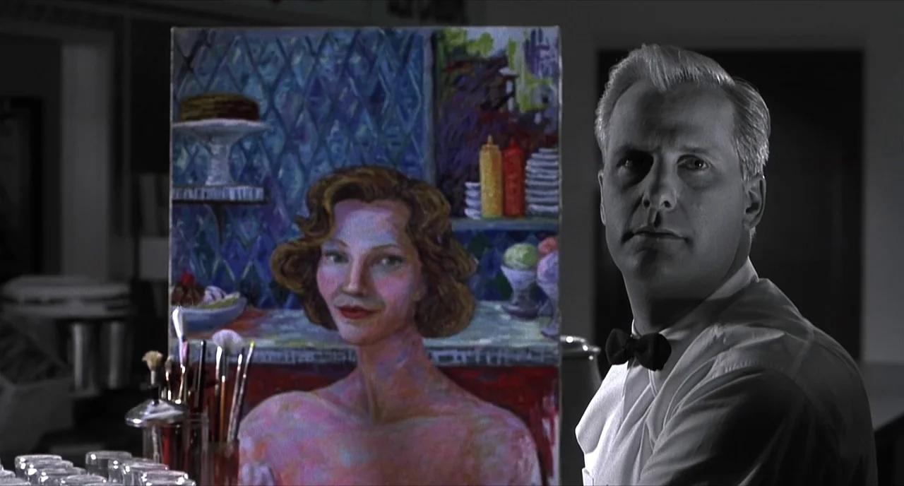 Pleasantville (1998) movie still: medium — A black and white diner interior features a man standing beside an easel. A colorful oil painting of a…