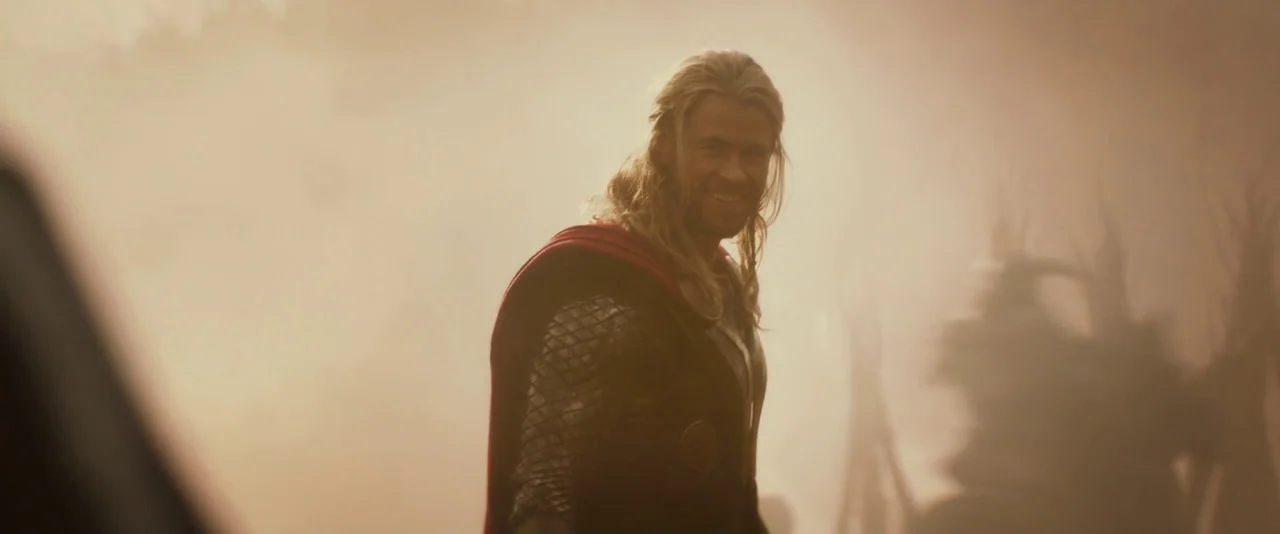 Thor: The Dark World (2013) movie still: medium — A dust-filled, hazy battlefield with blurred silhouettes of debris in the background. A muscular…