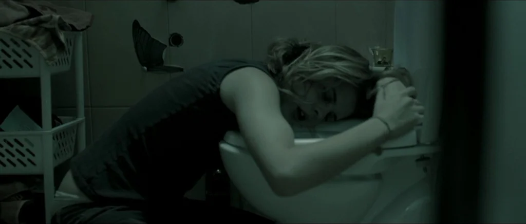 Lasting (Nieulotne) (2013) movie still: medium — A tiled restroom features a white ceramic fixture and a butterfly decal on the wall. A young woman…