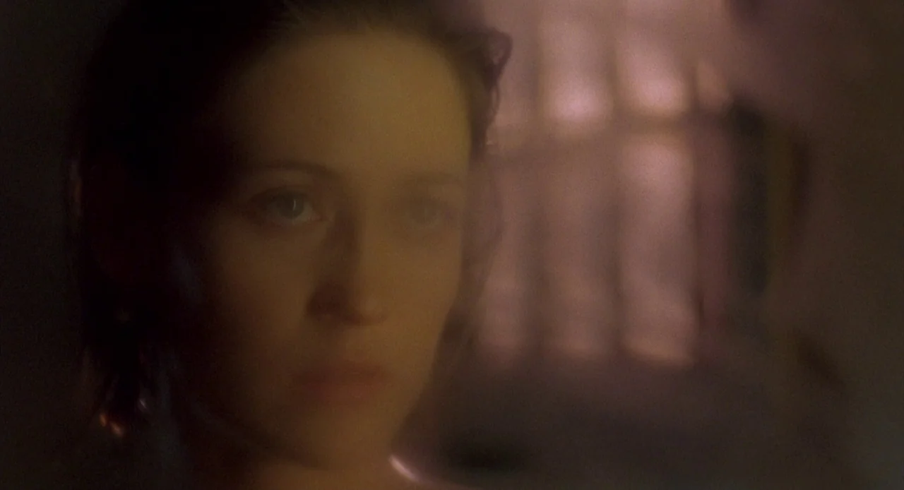 Candyman: Farewell to the Flesh (1995) movie still: closeup — A close view through a partially obscured, foggy glass pane in a dimly lit room. A…