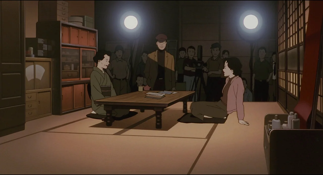 Millenium Actress (2001) movie still: wide — A film production set designed to look like a traditional Japanese room with tatami mats. Two women sit…