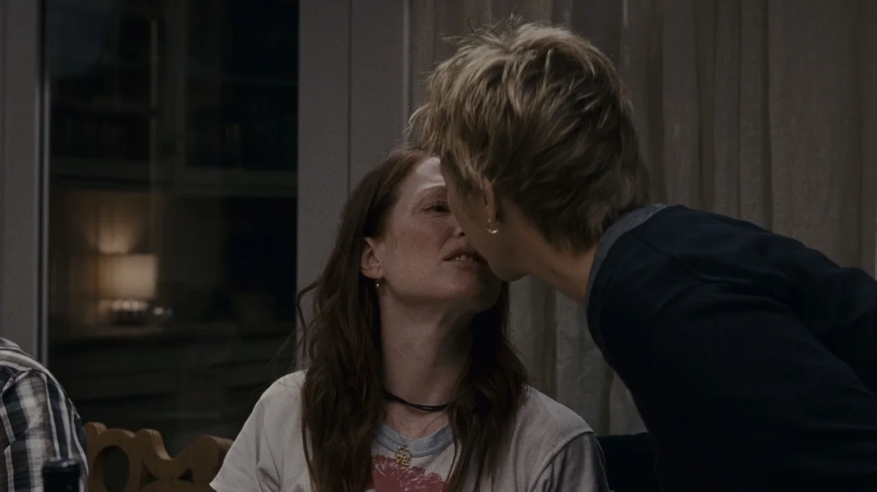 The Kids Are All Right (2010) movie still: medium — A domestic interior with draped curtains in the background and soft indoor lighting. Two women…