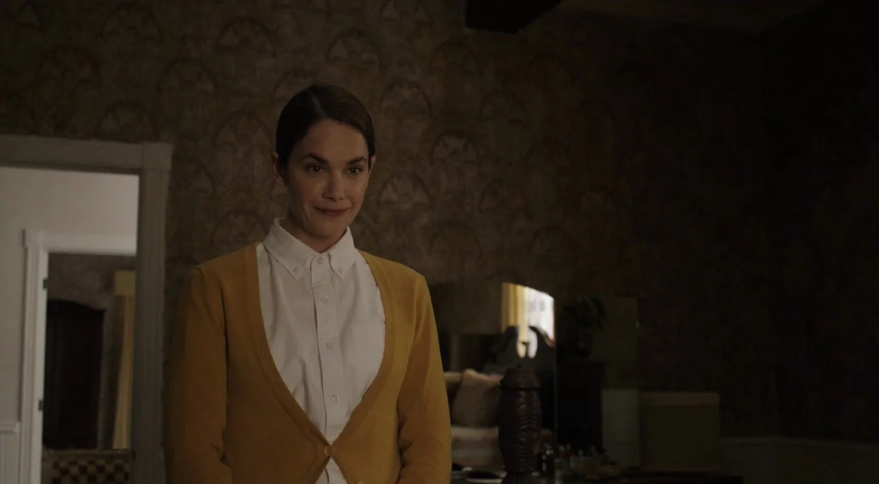 I Am The Pretty Thing That Lives In The House (2016) movie still: medium — A dimly lit room features patterned, dark-toned wallpaper and glimpses…
