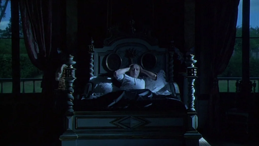 One Hundred and One Nights (1995) movie still: wide — A dark, ornate room contains a large four-poster bed positioned between two windows. A man…