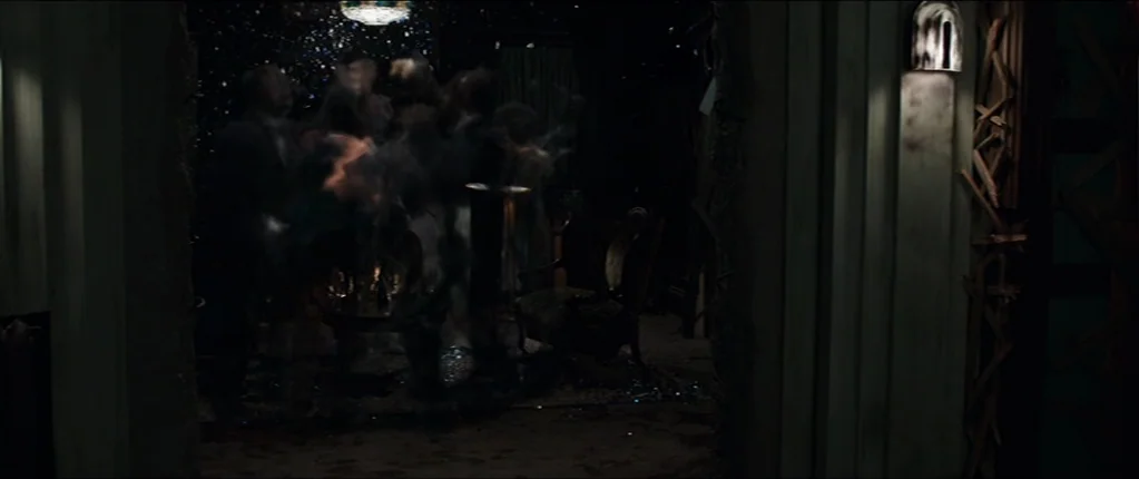 Abattoir (2016) movie still: wide — An dimly lit, traditional parlor interior features dark wooden walls and an ornate chair. Particles of dust or…