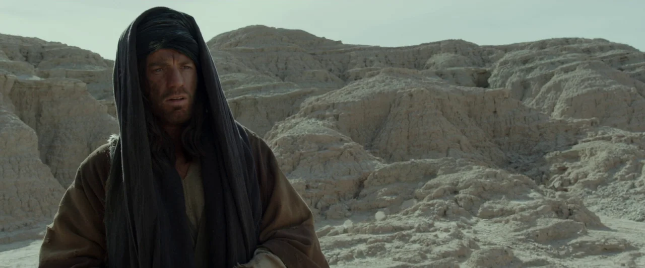 Last Days in the Desert (2015) movie still: medium — A vast, barren desert landscape features eroded light-colored rock formations under a pale sky.…