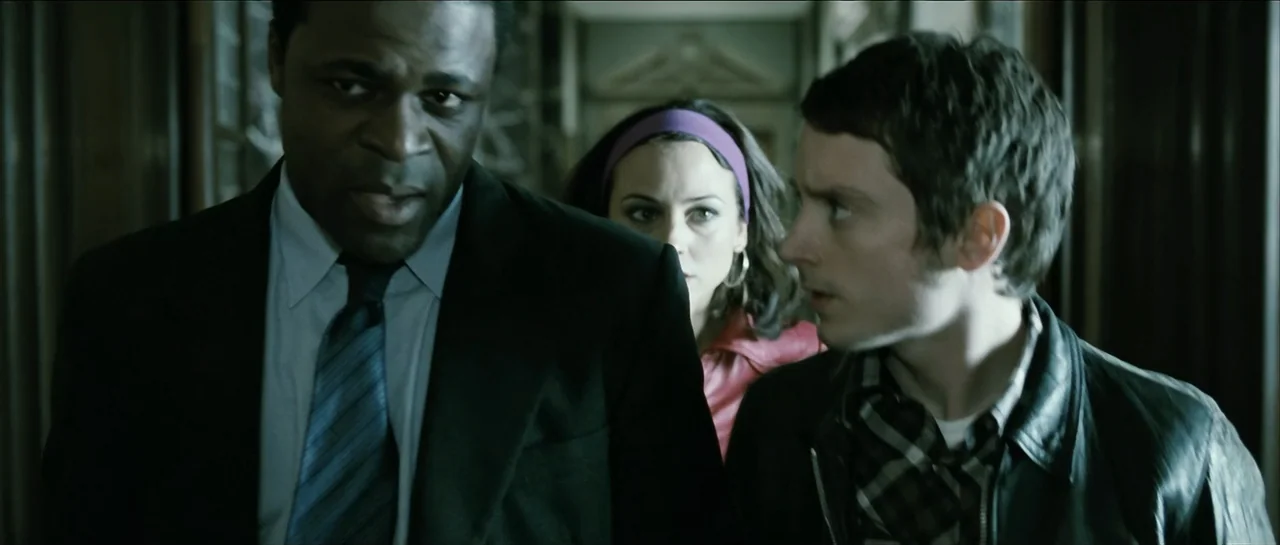 The Oxford Murders (2008) movie still: medium — A dimly lit narrow corridor features wood-paneled walls and a fading interior perspective. Three…