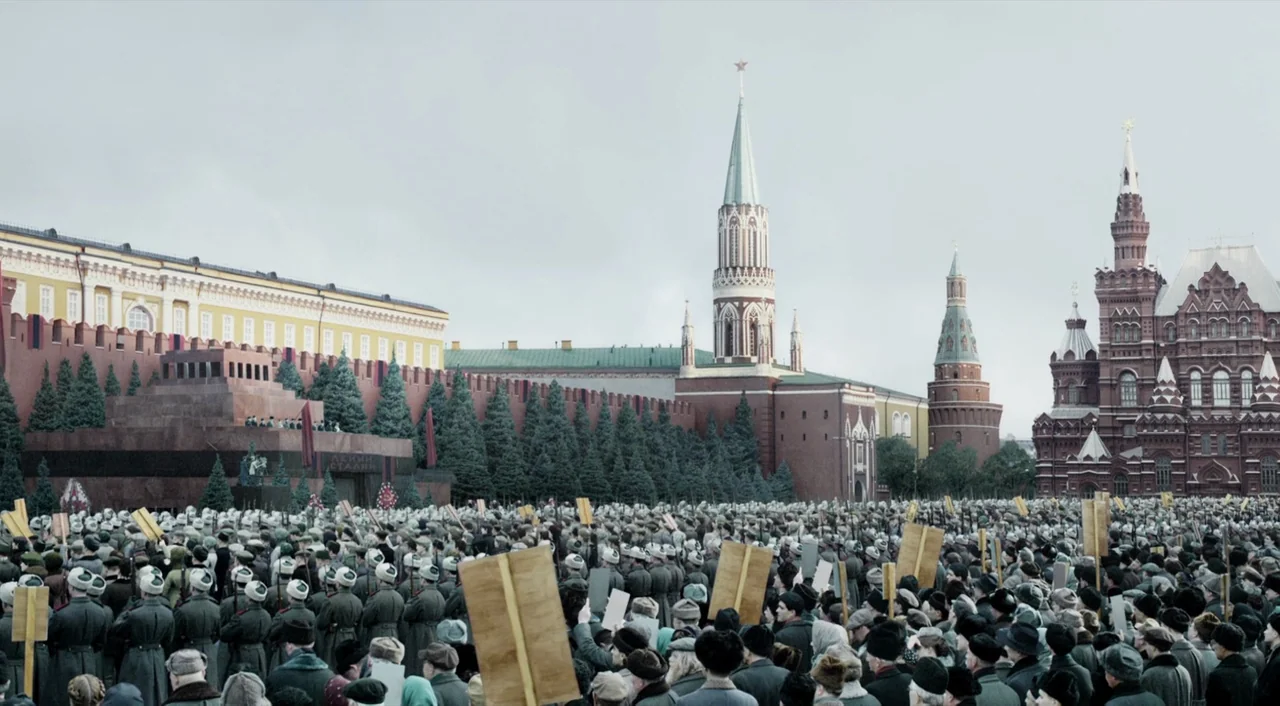 The Death of Stalin (2017) movie still: wide — A massive crowd fills Red Square under a grey, overcast sky during the day. Hundreds of individuals…