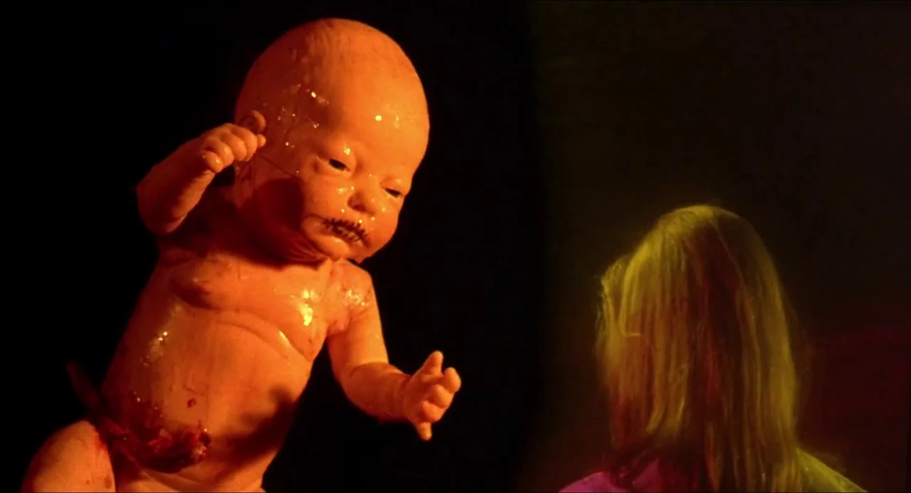 Hellbound: Hellraiser II (1988) movie still: medium — A dark, featureless void contains a suspended, wet infant figure with a deformed face. A…