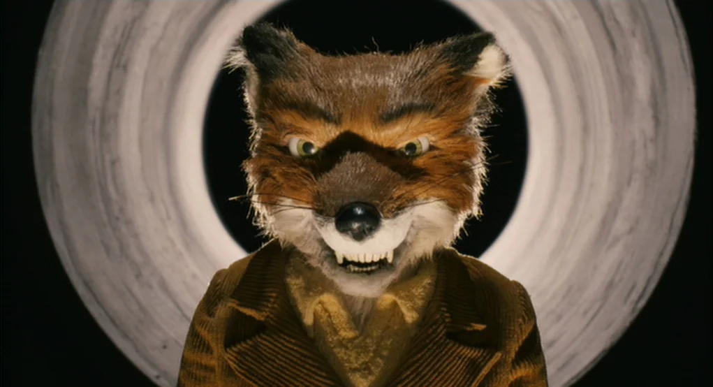 Fantastic Mr. Fox (2009) movie still: closeup — A dark space features a large illuminated white circular ring behind the main subject. An…