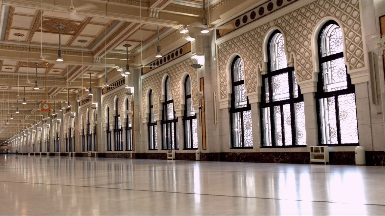 One Day in the Haram (2017) movie still: establishing — A grand, expansive prayer hall features polished marble floors and ornate, vaulted ceilings.…