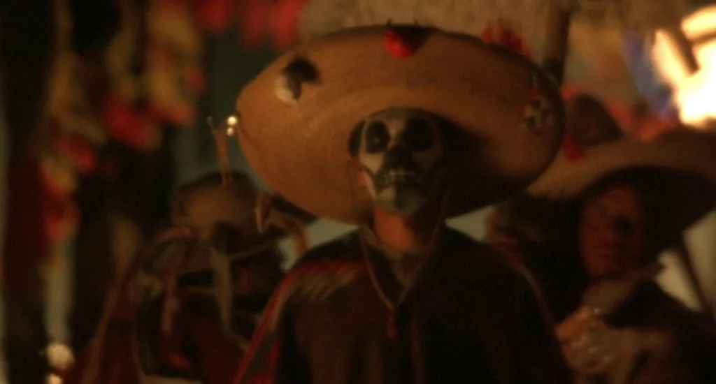 The Quick and the Dead (1995) movie still: medium — A night parade features people wearing traditional skull makeup and large brimmed straw…