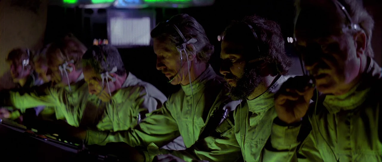 Star Wars (1977) movie still: medium — A dimly lit industrial control room features rows of technical monitors and operators. Several men in…