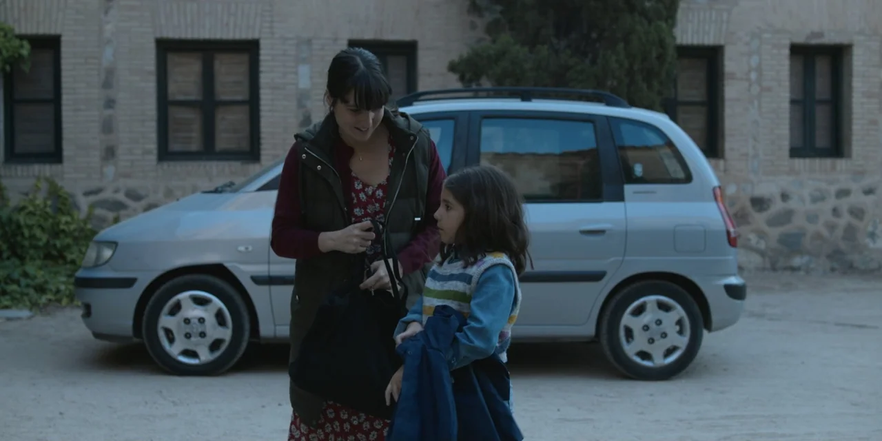 The Three Wise Men: The Truth (2022) movie still: medium — A gravel area sits in front of a brick building with a parked car. A woman interacts with…