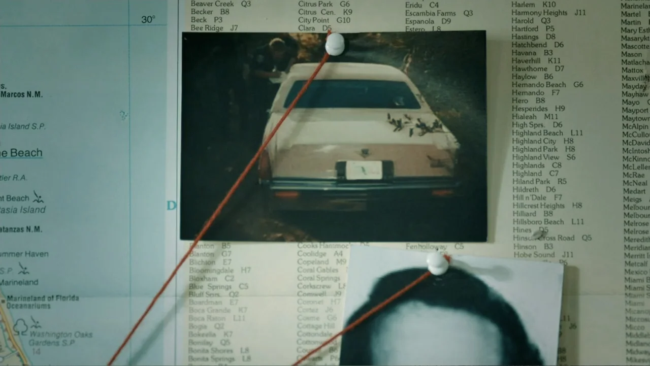 Aileen Wuornos : Mind of a Monster (2020) movie still: closeup — A large map of Florida is mounted on a wall, covered in geographic place names. Two…