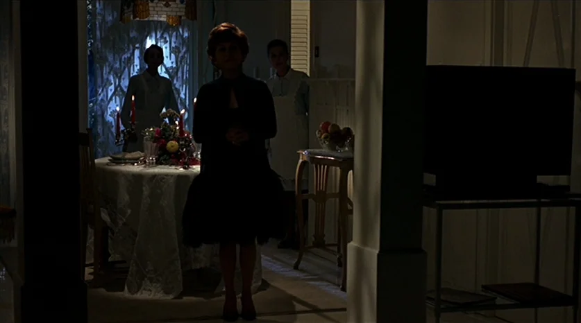 Juliet of the Spirits (1965) movie still: medium — A dimly lit room contains a dining table decorated with flowers and lit candles. One woman stands…