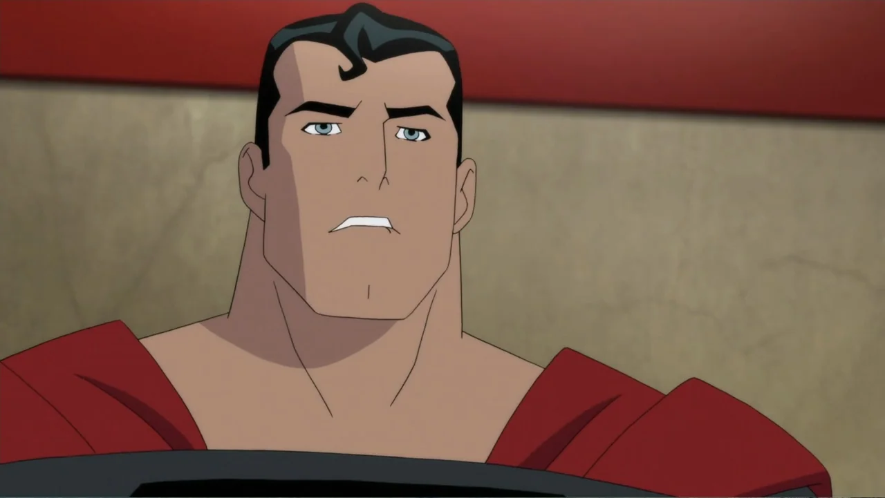 Superman: Red Son (2020) movie still: medium — An interior space with plain beige walls and a horizontal red stripe. A muscular man in a dark shirt…