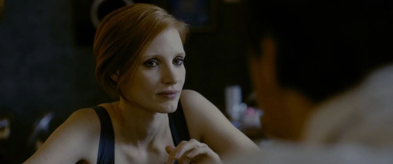 The Disappearance of Eleanor Rigby: Him (2014) movie still: closeup — A dimly lit room provides the backdrop for a quiet conversation. The woman…