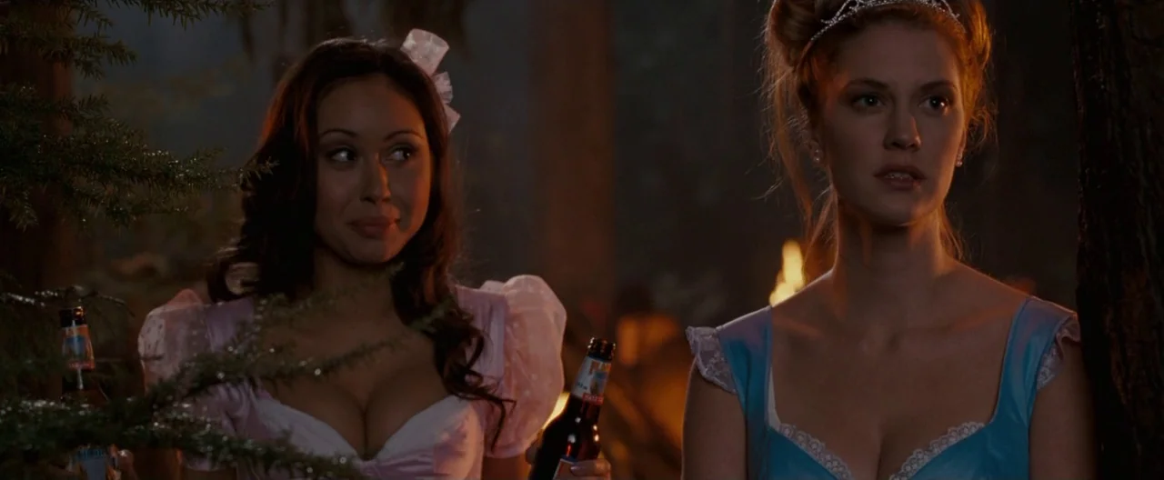 Trick ‘R Treat (2007) movie still: medium — Two women in princess costumes stand near trees in a dark, outdoor setting at night. Both women hold…