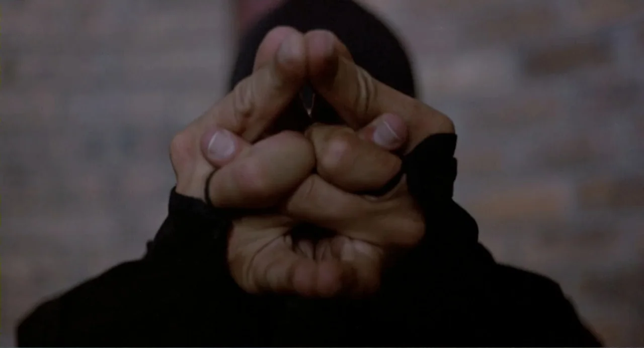American Ninja 2: The Confrontation (1987) movie still: closeup — A close-up view shows a pair of hands held together in a gesture. The background…